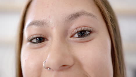 close-up of young asian woman smiling with nose piercing and natural makeup