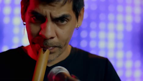 close up shot of musician playing recorder, blurry colorful lights in background