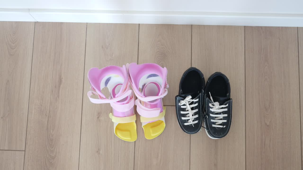 핑크색 정형 신발과 나무 바닥에 검은 신발 한