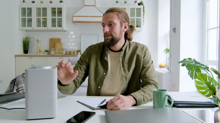 Mand sidder ved skrivebord i stuen
