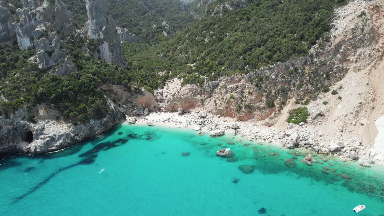 Aerial drone video of tropical paradise turquoise beach and sea cliffs in the mediterranean, Cala Goloritzè, Sardinia