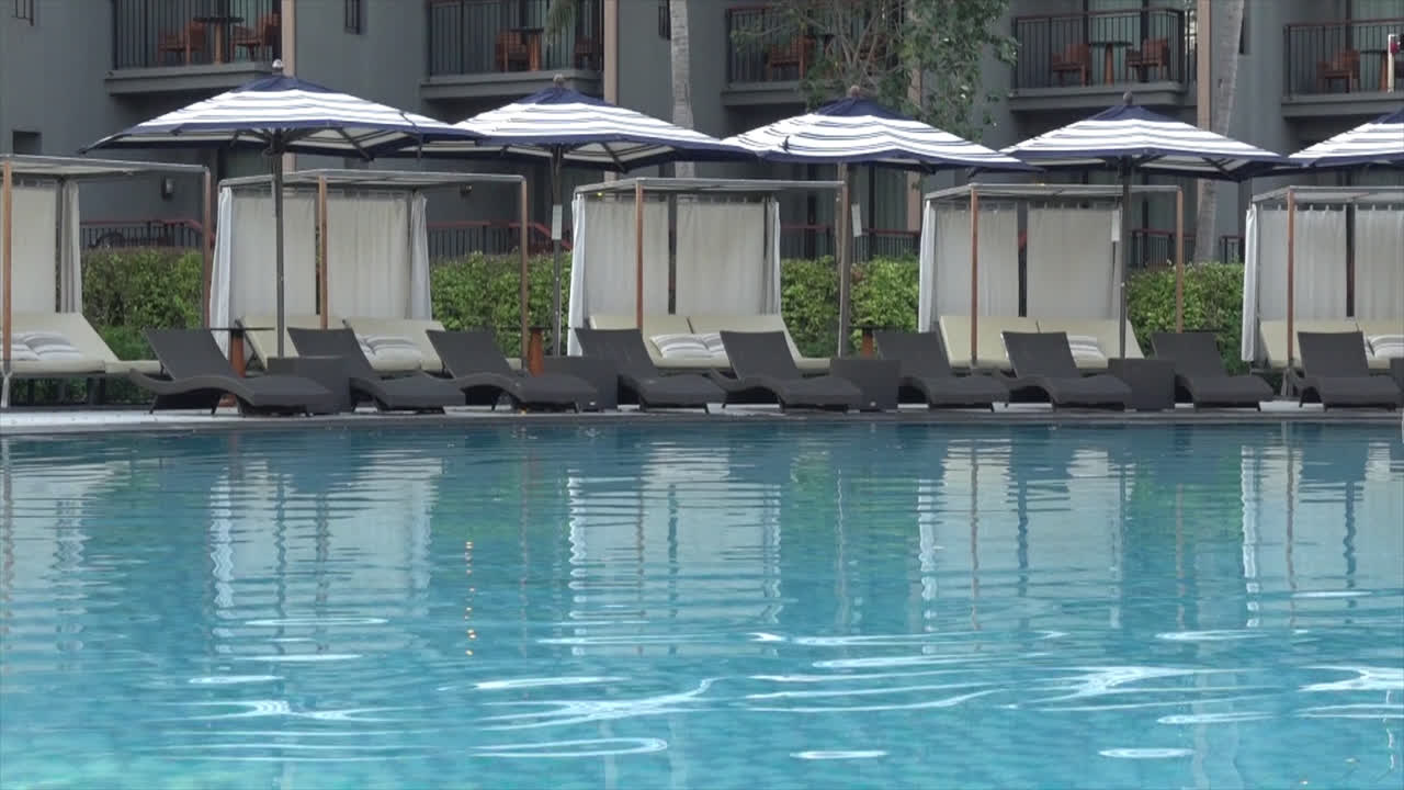 여행 휴가 휴가 개념-2를 위한 호텔 리조트의 야외 수영장 주변의 파라솔과 수영장 침대