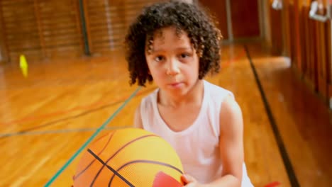 athletic african american schoolboy standing with basketball in basketball court at school 4k