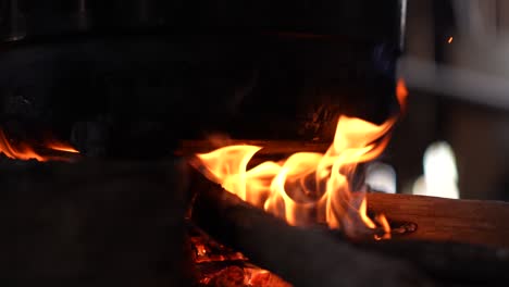 el fuego humeante arde perfectamente en la leña bajo un wok negro típico de la sociedad indonesia tradicional