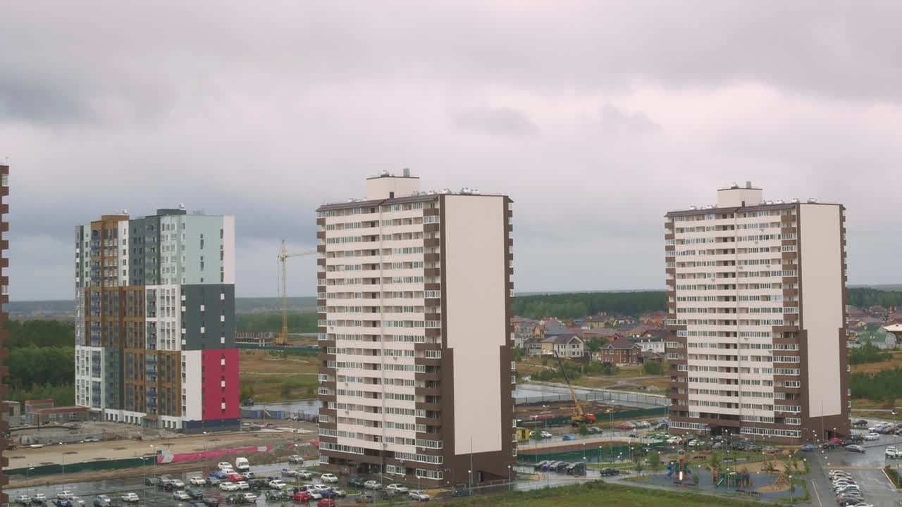 timelapse con efecto de zoom dinámico, un área para dormir con complejos de apartamentos y casas de un piso sobre las cuales vuelan nubes de lluvia. un área de las afueras de la ciudad que todavía está en construcción