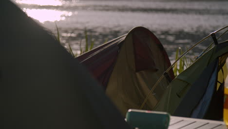 Tiendas-De-Campaña-Del-Festival-Cerca-De-Un-Lago-Por-La-Noche