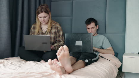 couple working from home on bed
