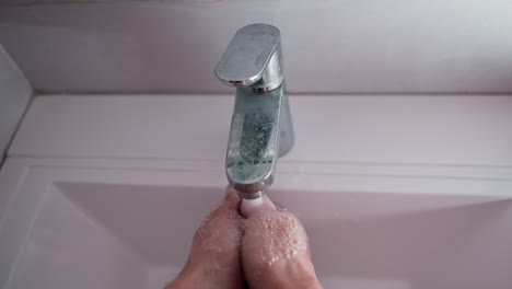 pov hand-washing sequence with tap water, including lathering, rinsing, and shaking off excess water, embodying cleanliness and hygiene