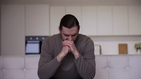 caucasian man with headache sitting on a chair