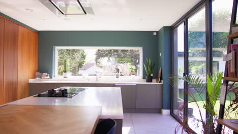 kitchen and counter with built in appliances in modern house with views to garden