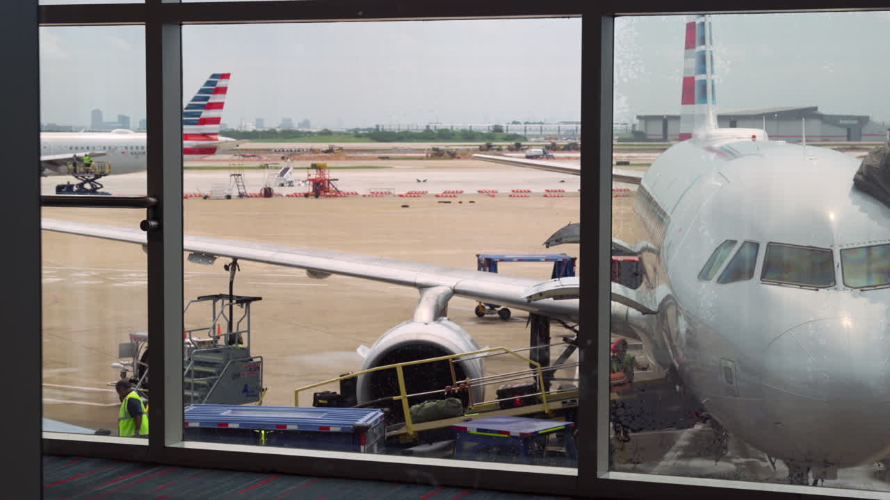 Airport workers loading the plane in Dallas airport, airport ambience background stationery shot.