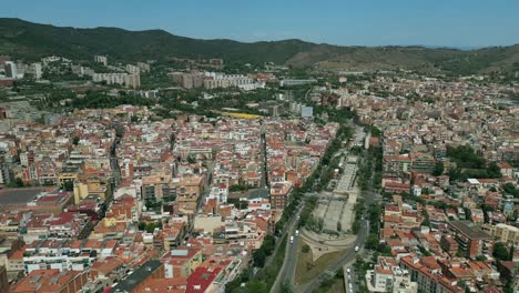 an aerial drone shot of a wide road in the center of barcelona city