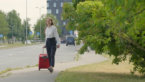 Joven-Empresaria-Caminando-Por-La-Carretera-Con-Una-Maleta