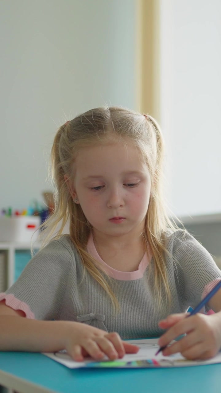Bambina concentrata mentre colora con sua madre