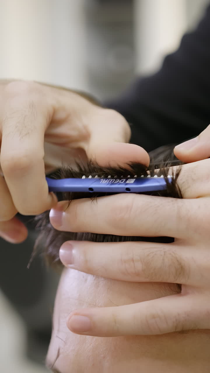 Primo piano di un barbiere che taglia i capelli a un uomo