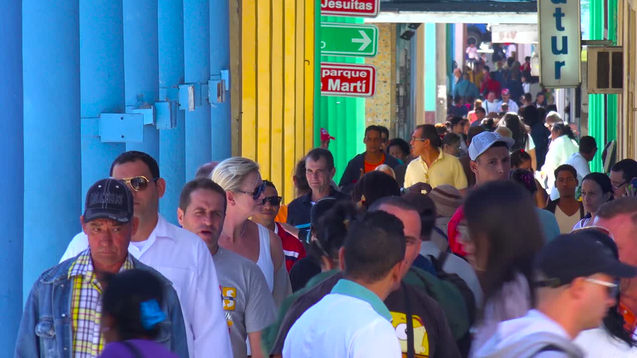 multitudes de cubanos caminan por las calles de cienfuegos en un buen día