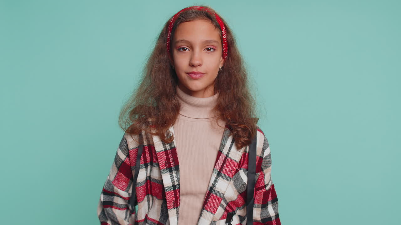 Child girl pointing to camera and looking with happy expression, making choice, showing direction