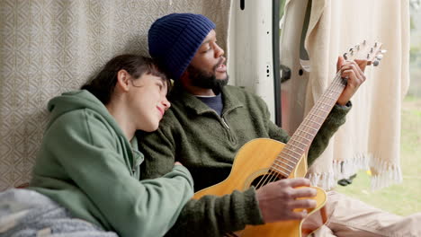 Couple,-guitar-and-singing-in-camper