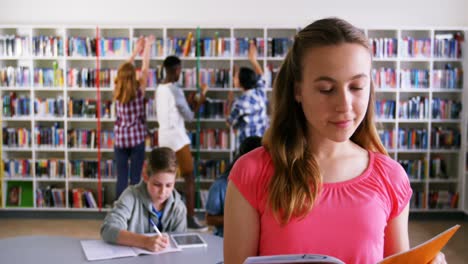 Portrait-of-happy-schoolgirl-reading-book-4k