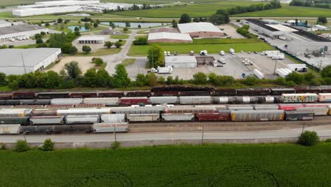 4k aerial view panning left to right of multiple trains and one starting to leave the train station