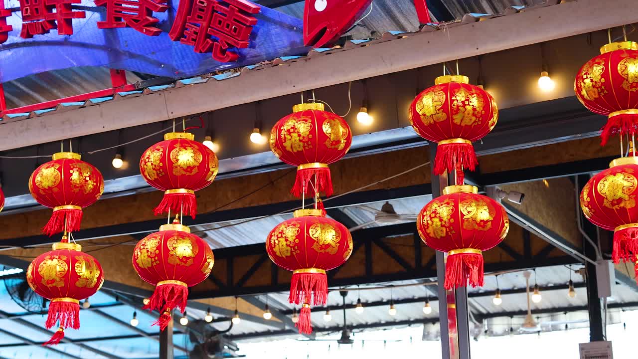 las linternas rojas se balancean suavemente en un bullicioso mercado de phuket, creando una atmósfera festiva con colores brillantes y movimiento dinámico