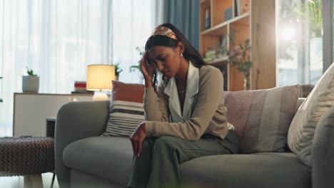 a woman sitting on a couch looking sad and stressed