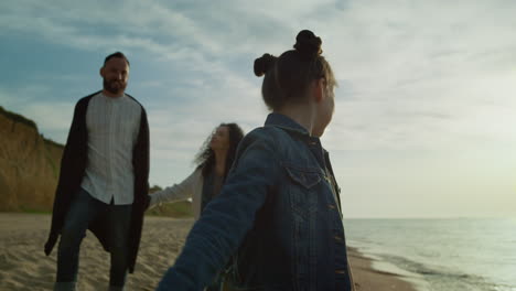 parents girl walk coast by sunrise sea waves. family enjoy ocean beach holiday.