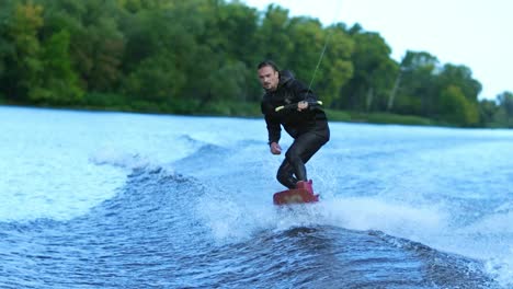 Wakeboarder-waterskiing-on-river-behind-boat.-Wake-boarding-rider