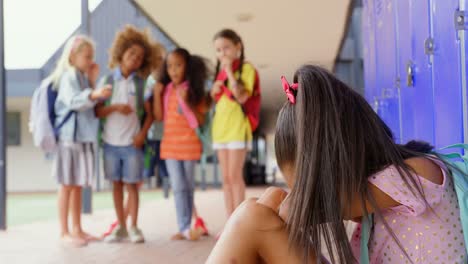 escolares intimidando a una niña asiática llorando en el corredor de la escuela primaria 4k