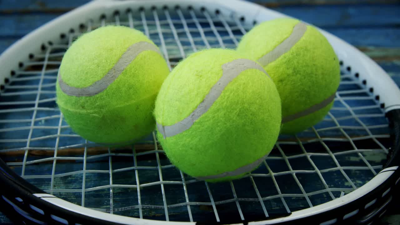 Three tennis balls on racket 4k