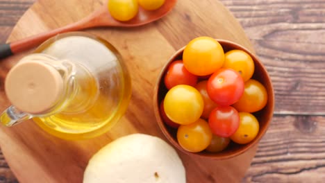 tomates de cereza, aceite de oliva y utensilios de madera