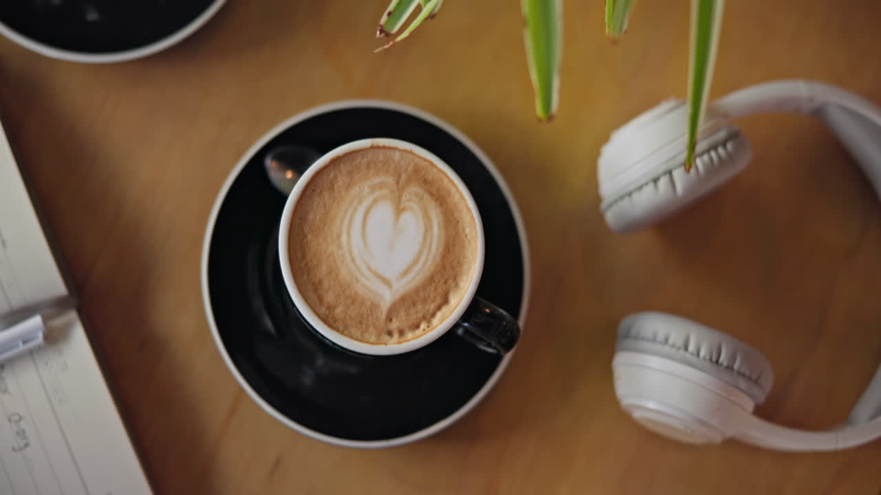 Café, notebook e fones de ouvido na mesa