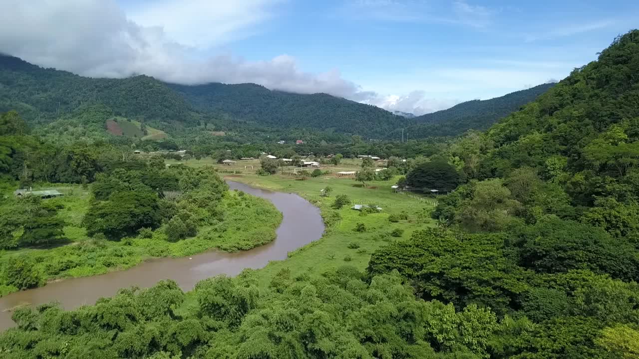 태국 북부의 무성한 녹색 산으로 둘러싸인 계곡을 흐르는 바람이 부는 강