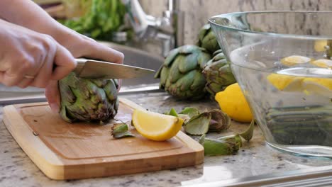 mujer cortar alcachofas. proceso de cocción en la cocina