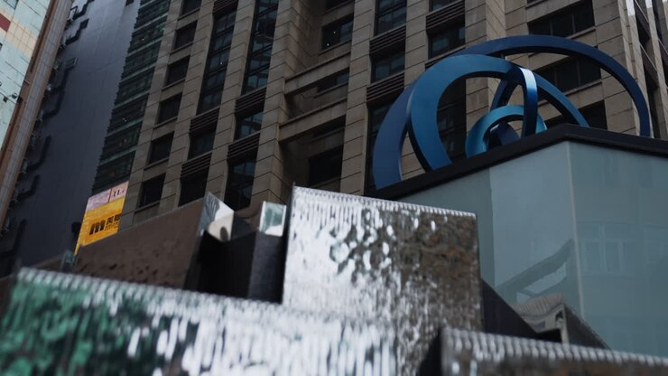 Inquadratura dal basso di un'opera d'arte rotante di fronte a Times Square, Hong Kong - Grattacielo sullo sfondo.