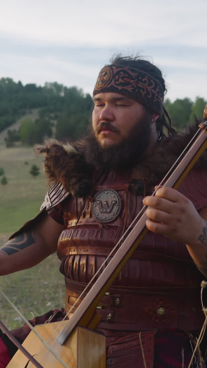 Calm Altai music player ikili stringed instrument performs in mountain valley meadow. Mystical sounds of folk music for meditation. Nature and spirit