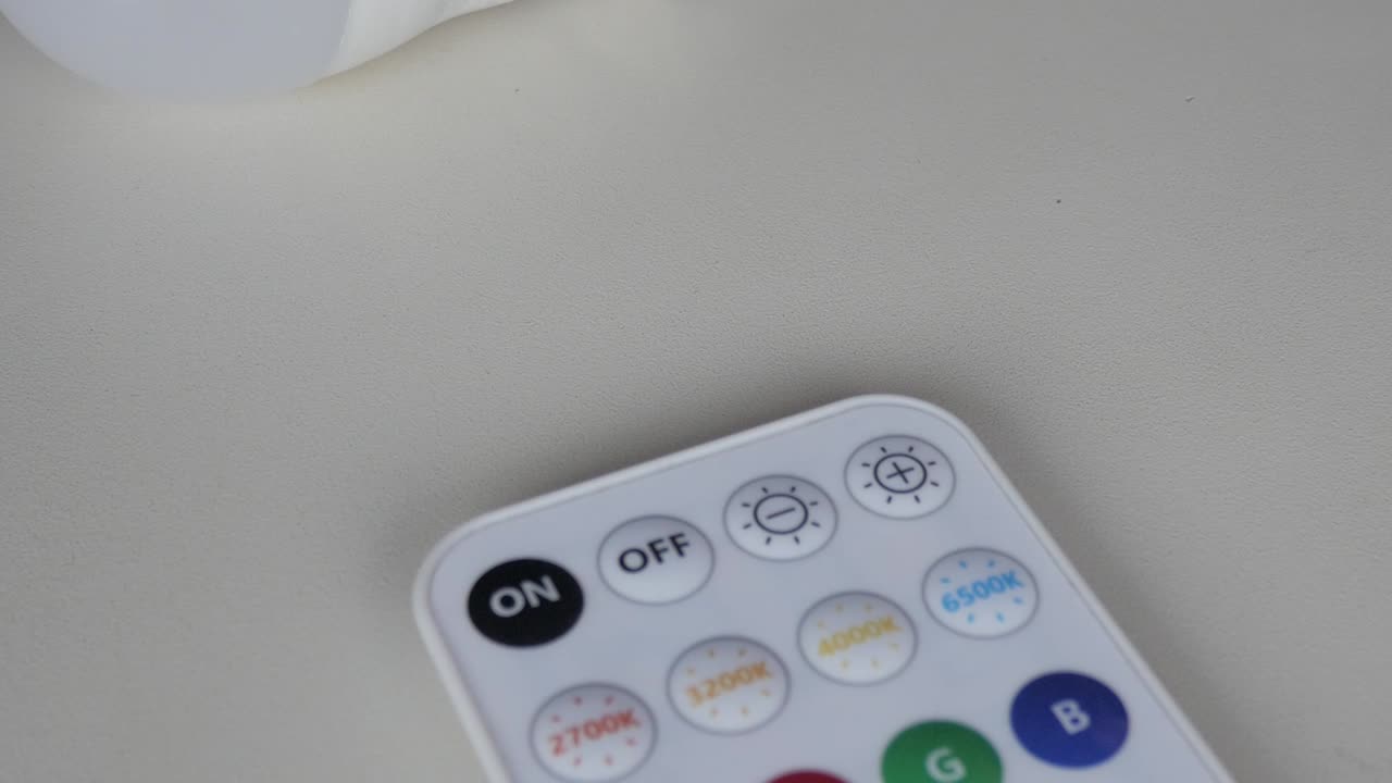 Smart bulb and remote on neutral background, symbolizing modern tech