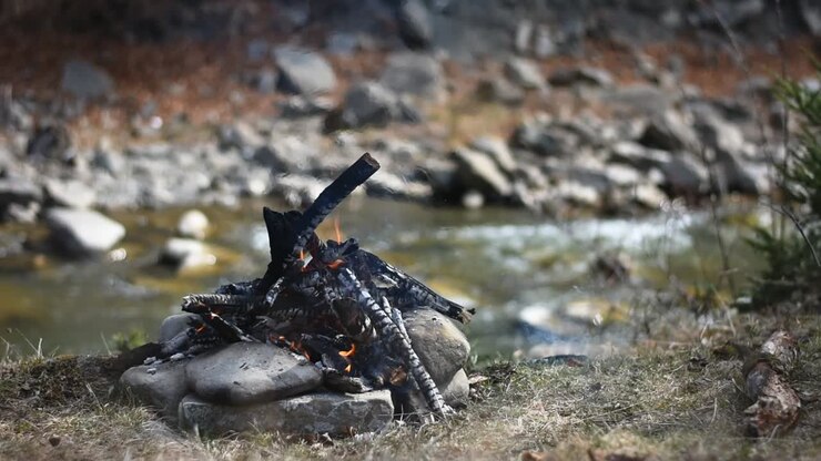 Burning campfire on the side of the river