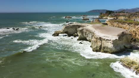 scenic view overlooking white stone cliffs with wave splashing and crashing along the rocky shore