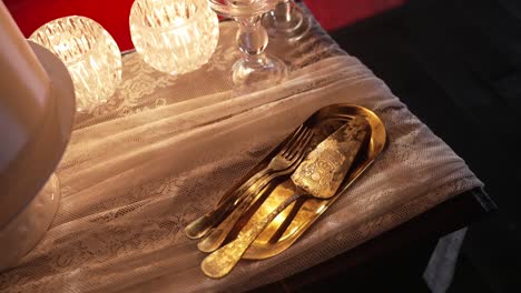 elegant gold cake knife and fork on lace tablecloth