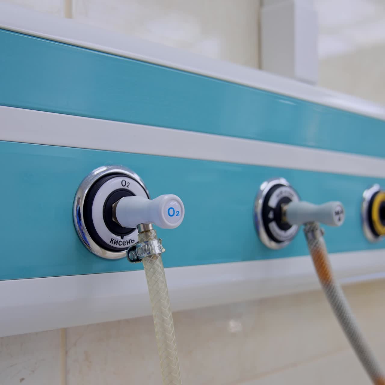 Panel with connected wires on the wall of surgical room. Close up. Blurred backdrop with other equipment in operational theatre