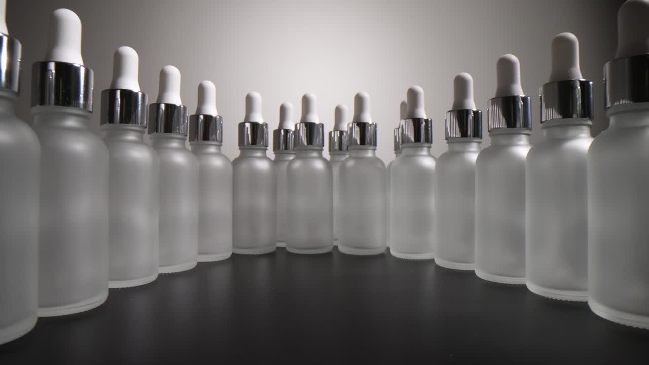 Row of Frosted Glass Dropper Bottles with Silver Caps