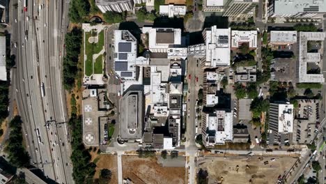 Overhead-drone-shot-of-Seattle-neighborhoods-with-cars-filling-the-nearby-freeway