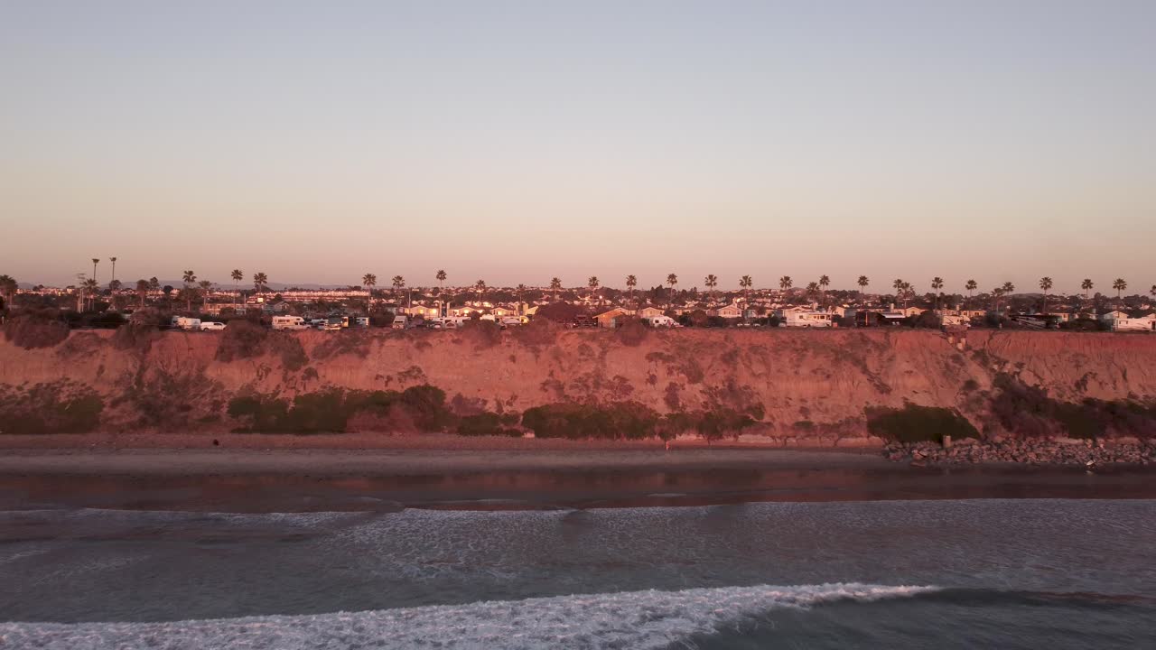 아름다운 공중 드론 샷, 수평선과 풍경을 바라보며 바다로 뒤로 날아가는 드론, 칼즈배드 주립 해변 - 캘리포니아