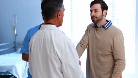 los médicos hablando con el hombre en la sala