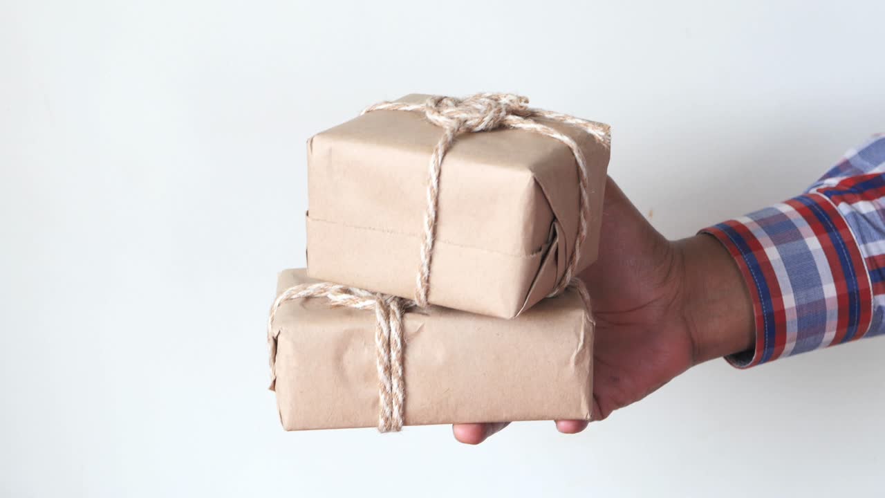 손으로 포장된 선물을 들고