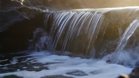 small waterfall with golden sunlight