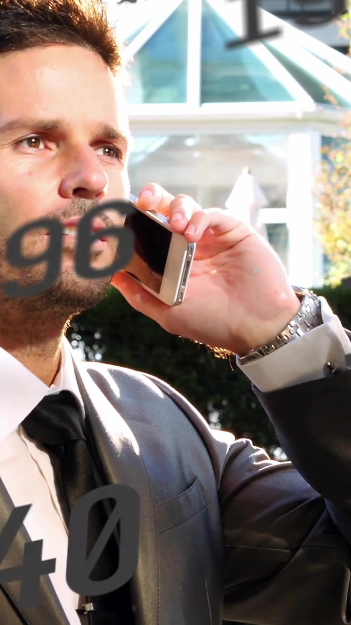 Video verticale: Uomo che porta il telefono all'orecchio, in una chiamata di lavoro mentre dei numeri scorrono sul suo viso.