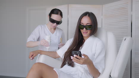 laser epilation. woman getting laser hair removal procedure on her legs. beauty laser treatment salon clinic cosmetology beautician professional profession body care concept