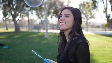 una linda joven haciendo burbujas y siendo juguetona y feliz al aire libre bajo el sol